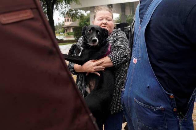 Mulher carrega seu cachorro para um caminhão militar durante evacuação de áreas inundadas após passagem do furacão Harvey em Dickinson, no estado americano do Texas - 27/08/2017 Mulher carrega seu cachorro para um caminhão militar durante evacuação de áreas inundadas após passagem do furacão Harvey em Dickinson, no estado americano do Texas - 27/08/2017