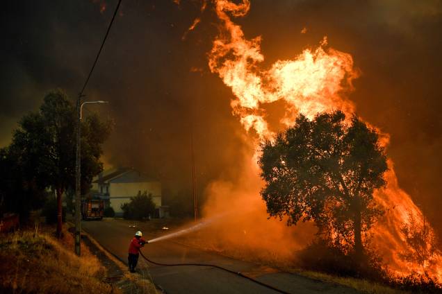 Bombeiro tenta extinguir o fogo do incêndio florestal que atingiu a vila de Pucarica, na cidade de Abrantes, Portugal Bombeiro tenta extinguir o fogo do incêndio florestal que atingiu a vila de Pucarica, na cidade de Abrantes, Portugal