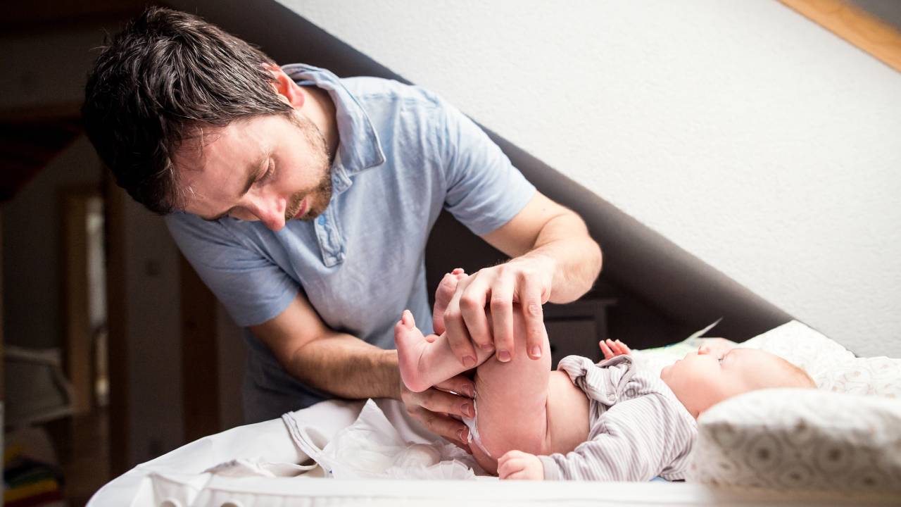 Pai trocando a fralda de seu bebê