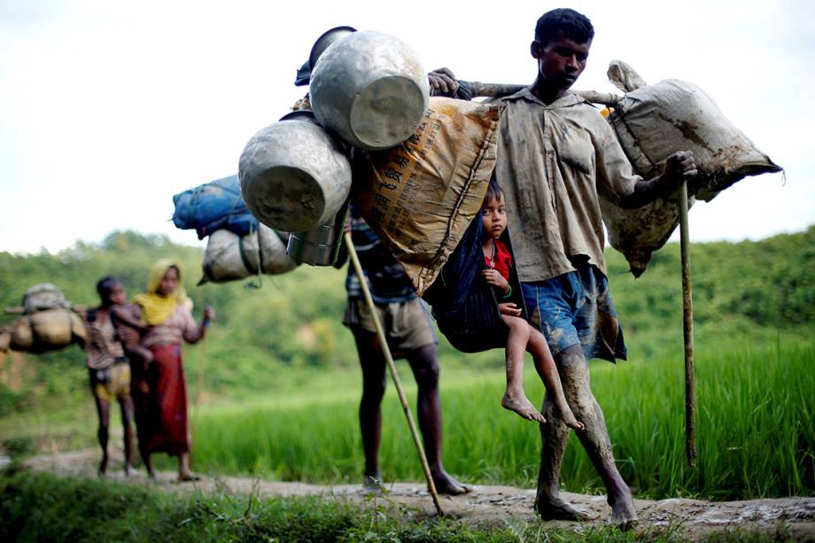 Refugiados rohyngias caminham por uma trilha em um campo de arroz, na travessia entre as fronteiras de Myanmar e Bangladesh - 08/09/2017