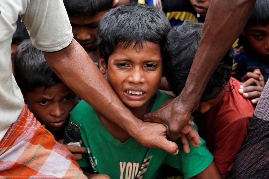 Crianças refugiadas aguardam para receberem comida distribuída por uma ONG local, em BangladeshMulçumanos rohyngias sentam em frente a uma fogueira, em um acampamento para refugiados, em Bangladesh - 09/09/2017