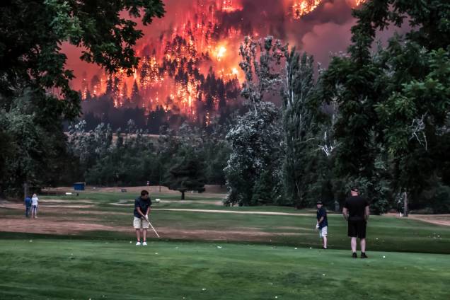 Foto tirada em 4 de setembro mostra pessoas jogando golfe durante um incêndio incêndio florestal em North Bonneville, Washington, Estados Unidos - 04/09/2017 Foto tirada em 4 de setembro mostra pessoas jogando golfe durante um incêndio incêndio florestal em North Bonneville, Washington, Estados Unidos - 04/09/2017