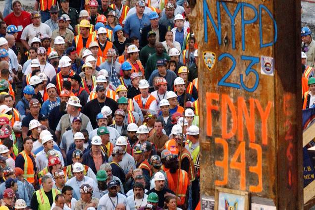 Trabalhadores civis se reúnem durante retirada da última viga que ficou de pé após atentado do 11 de setembro às torres gêmes, em Nova York Trabalhadores civis se reúnem durante retirada da última viga que ficou de pé após atentado do 11 de setembro às torres gêmes, em Nova York