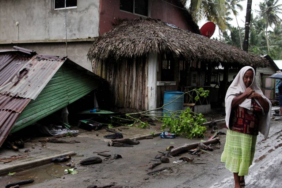 Mulher passa ao lado de uma casa danificada pela passagem do furacão Irma na costa da República Dominicana, em Nagua - 07/09/2017