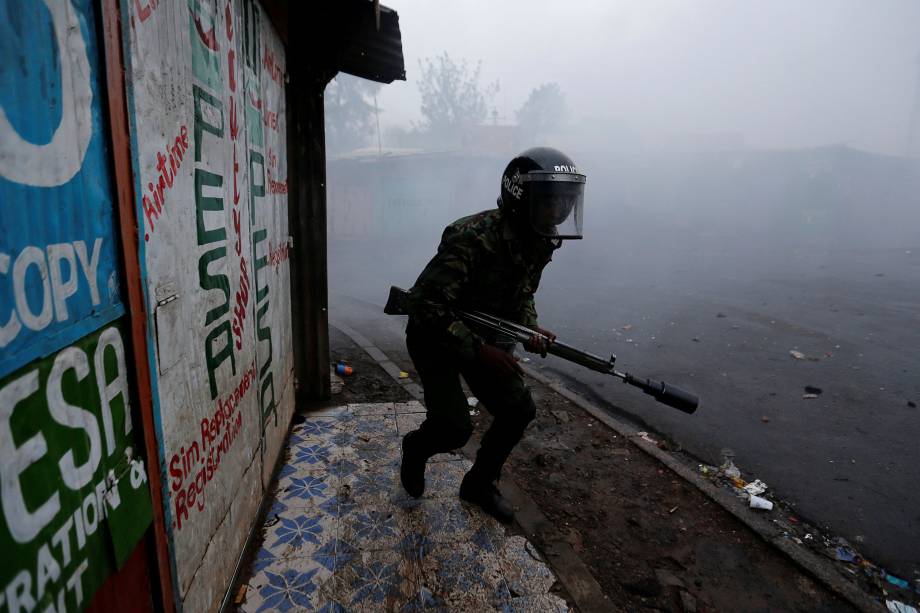 Policial tenta dispersar partidários do líder da oposição queniana, Raila Odinga, que protestam contra a eleição presidencial na favela de Kibera em Nairóbi, no Quênia - 26/10/2017