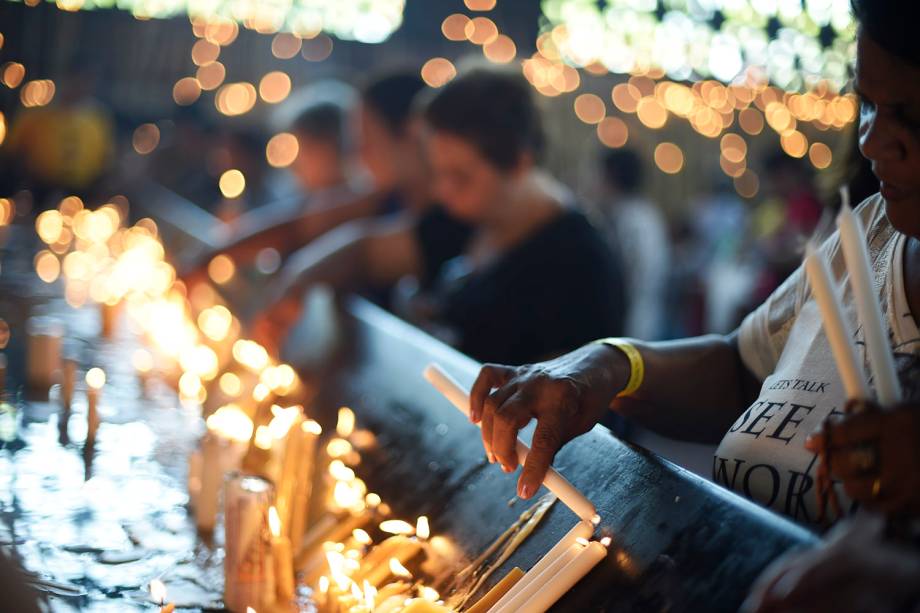 Fiel acende vela durante a véspera do dia de Nossa Senhora Aparecida