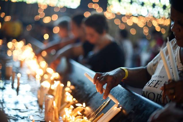 Fiel acende vela durante a véspera do dia de Nossa Senhora Aparecida Fiel acende vela durante a véspera do dia de Nossa Senhora Aparecida