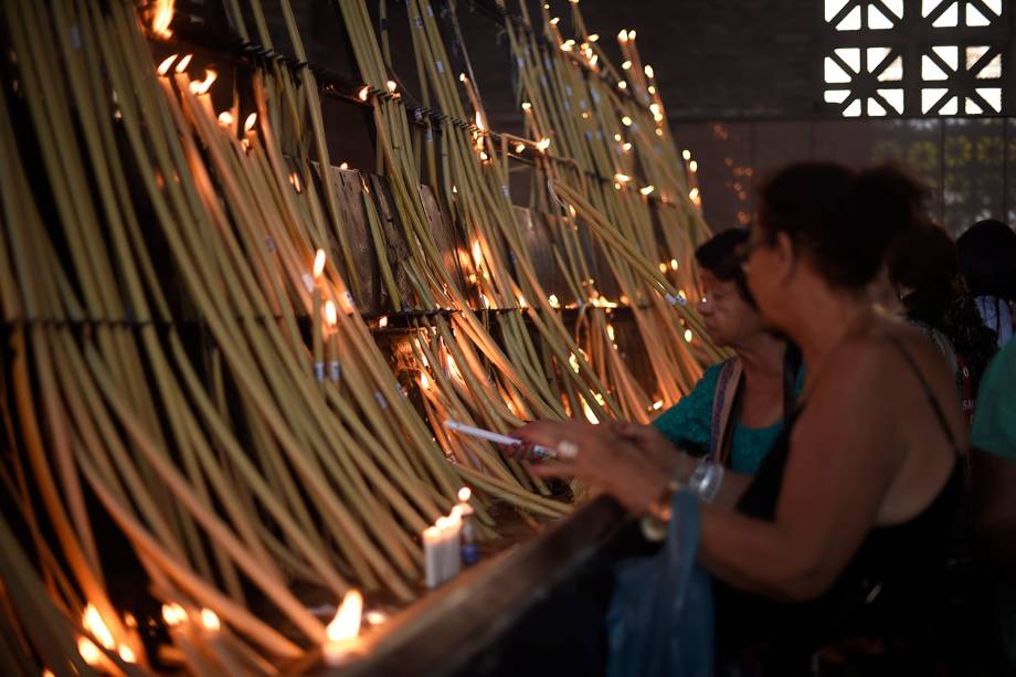 Fiéis acendem vela durante a véspera do dia de Nossa Senhora Aparecida