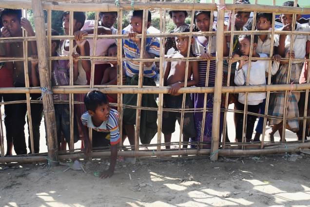Jovens muçulmanos rohingyas ficam atrás de uma barricada de bambu para coletar comida cozida no campo de refugiados de Thankhali, no distrito de Ukhia, em Bangladesh - 10/11/2017 Jovens muçulmanos rohingyas ficam atrás de uma barricada de bambu para coletar comida cozida no campo de refugiados de Thankhali, no distrito de Ukhia, em Bangladesh - 10/11/2017