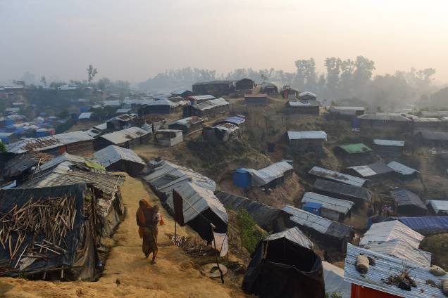 Mulher caminha com uma criança no colo no campo de refugiados de Balukhali, no distrito bengali de Ukhia - 23/11/2017 Mulher caminha com uma criança no colo no campo de refugiados de Balukhali, no distrito bengali de Ukhia - 23/11/2017