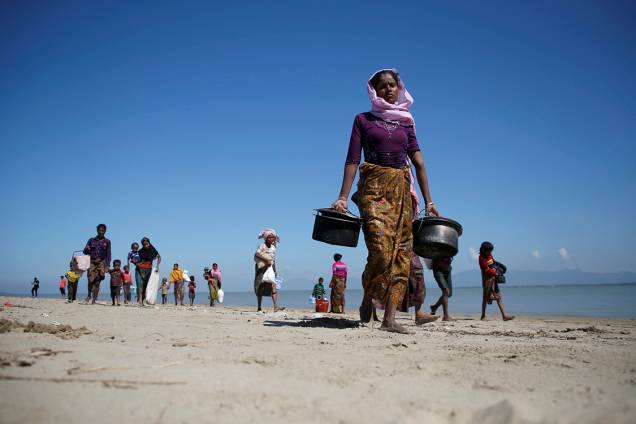 Refugiados caminham na praia após atravessarem a fronteira entre Mianmar e Bangladesh - 21/11/2017 Refugiados caminham na praia após atravessarem a fronteira entre Mianmar e Bangladesh - 21/11/2017