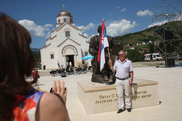 Homem segura bandeira sérvia, na aldeia de Andricgrad, República Srpska. Homem segura bandeira sérvia, na aldeia de Andricgrad, República Srpska.