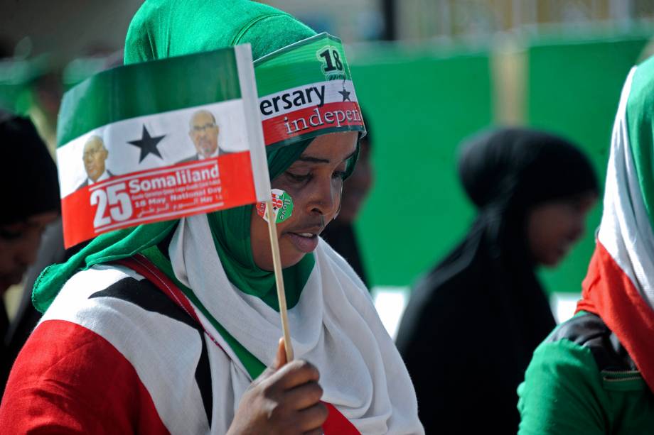 Mulher balança bandeira durante desfile do Dia da Independência em Hargeisa, Somalilândia.