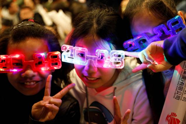 Crianças usam óculos luminosos para celebrar a chegada de 2018 em Hong Kong Crianças usam óculos luminosos para celebrar a chegada de 2018 em Hong Kong