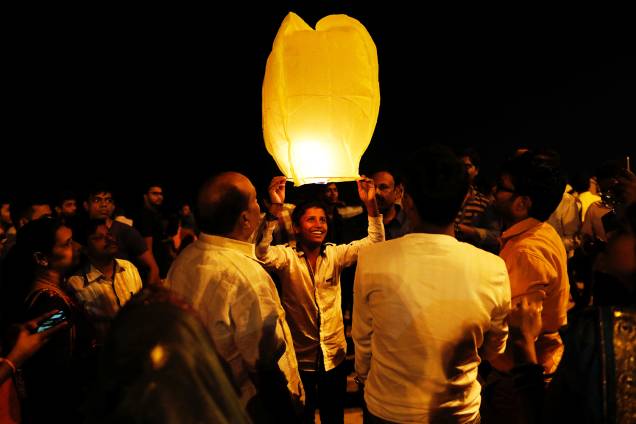 Homem segura lanterna para celebrar o Ano Novo em uma praia de Mumbai, na Índia Homem segura lanterna para celebrar o Ano Novo em uma praia de Mumbai, na Índia