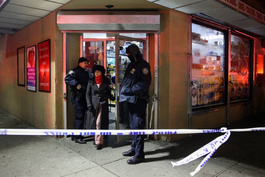 Policiais auxiliam a saída de moradores de um edifício de apartamentos durante incêndio no bairro do Bronx, em Nova York - 28/12/2017