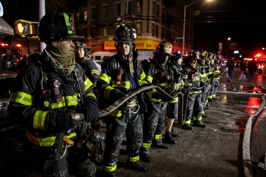 Bombeiros trabalham para controlar um incêndio e resgatar as vítimas em um edifício de apartamentos no bairro do Bronx, em Nova York - 28/12/2017