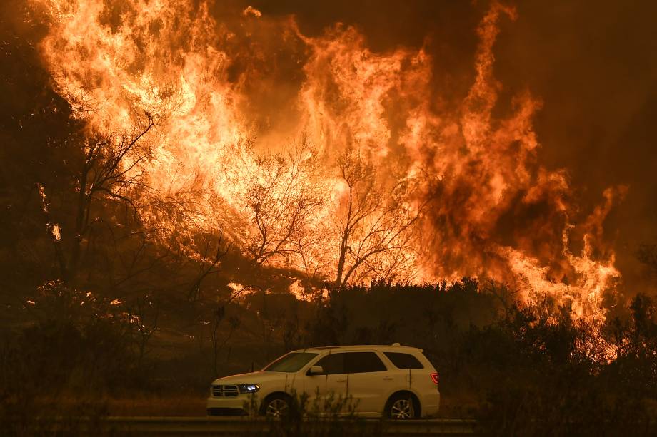 Veículo atravessa uma estrada em meio às chamas durante o incêndio Thomas Fire perto de Ventura, na Califórnia - 06/12/2017