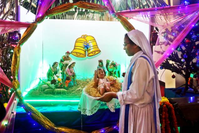 Freira segura Jesus Cristo em uma manjedoura na Catedral de Santa Maria, em Daca, capital de Bangladesh - 24/12/2017 Freira segura Jesus Cristo em uma manjedoura na Catedral de Santa Maria, em Daca, capital de Bangladesh - 24/12/2017