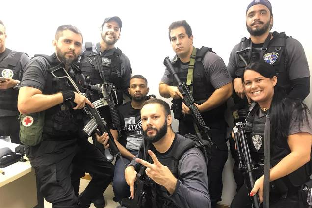 Policiais posam armados para foto com o traficante Rogério 157 após sua apreensão Policiais posam armados para foto com o traficante Rogério 157 após sua apreensão
