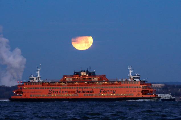 Superlua azul de sangue é vista do bairro do Brooklyn, atrás de uma Balsa de Staten Island, em Nova York Superlua azul de sangue é vista do bairro do Brooklyn, atrás de uma Balsa de Staten Island, em Nova York