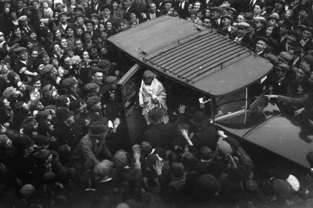Centenas de pessoas acompanham a chegada de Gandhi a Londres para uma conferência sobre a reforma constitucional da Índia, em 1931 Centenas de pessoas acompanham a chegada de Gandhi a Londres para uma conferência sobre a reforma constitucional da Índia, em 1931