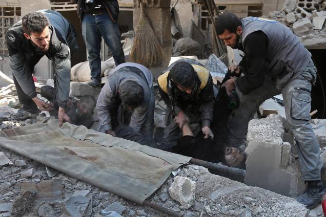 Membros da defesa civil síria resgatam um homem dos escombros após ataque aéreo das forças do governo no reduto rebelde de Hamouria, na região sitiada de Ghouta Oriental - 21/02/2018 Membros da defesa civil síria resgatam um homem dos escombros após ataque aéreo das forças do governo no reduto rebelde de Hamouria, na região sitiada de Ghouta Oriental - 21/02/2018