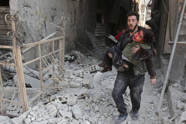 Homem resgata uma criança ferida após ataque aéreo das forças do governo sírio no reduto rebelde de Hamouria, na região sitiada de Ghouta Oriental nos arredores da capital, Damasco - 21/02/2018 Homem resgata uma criança ferida após ataque aéreo das forças do governo sírio no reduto rebelde de Hamouria, na região sitiada de Ghouta Oriental nos arredores da capital, Damasco - 21/02/2018