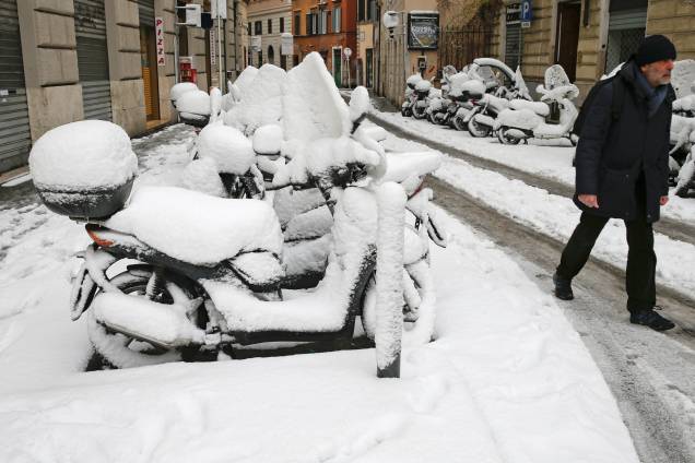 Um homem caminha ao lado de um estacionamento, onde todas as motocicletas estão cobertas de neve, devido a uma onda de frio que congelou a cidade de Roma, na Itália - 26/02/2018 Um homem caminha ao lado de um estacionamento, onde todas as motocicletas estão cobertas de neve, devido a uma onda de frio que congelou a cidade de Roma, na Itália - 26/02/2018
