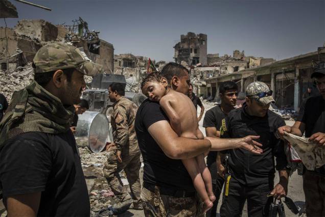 Um garoto não identificado, que foi levado da última área controlada pelo ISIS na Cidade Velha de Mossul por um homem suspeito de ser militante, é carregado pelos soldados iraquianos das Forças Especiais - 12/07/2017 Um garoto não identificado, que foi levado da última área controlada pelo ISIS na Cidade Velha de Mossul por um homem suspeito de ser militante, é carregado pelos soldados iraquianos das Forças Especiais - 12/07/2017