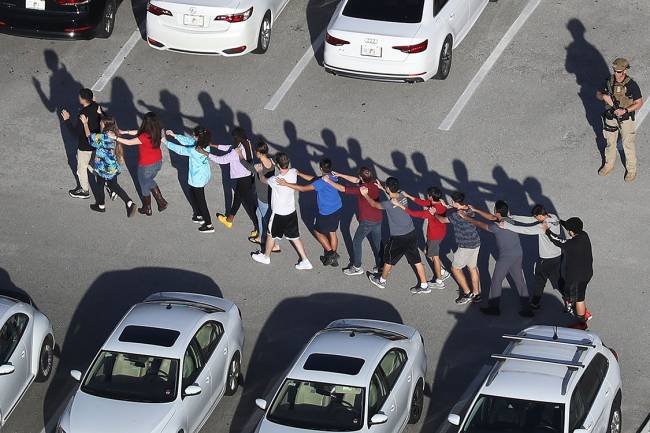 Pessoas são retiradas da escola Marjory Stoneman Douglas, após tiroteio que deixou mortos e feridos na cidade de Parkland, Flórida