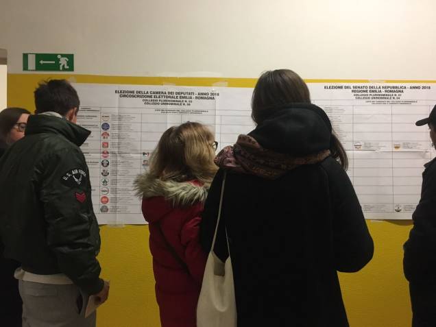 Eleitores leem a lista de candidatos em uma escola em Bolonha Eleitores leem a lista de candidatos em uma escola em Bolonha