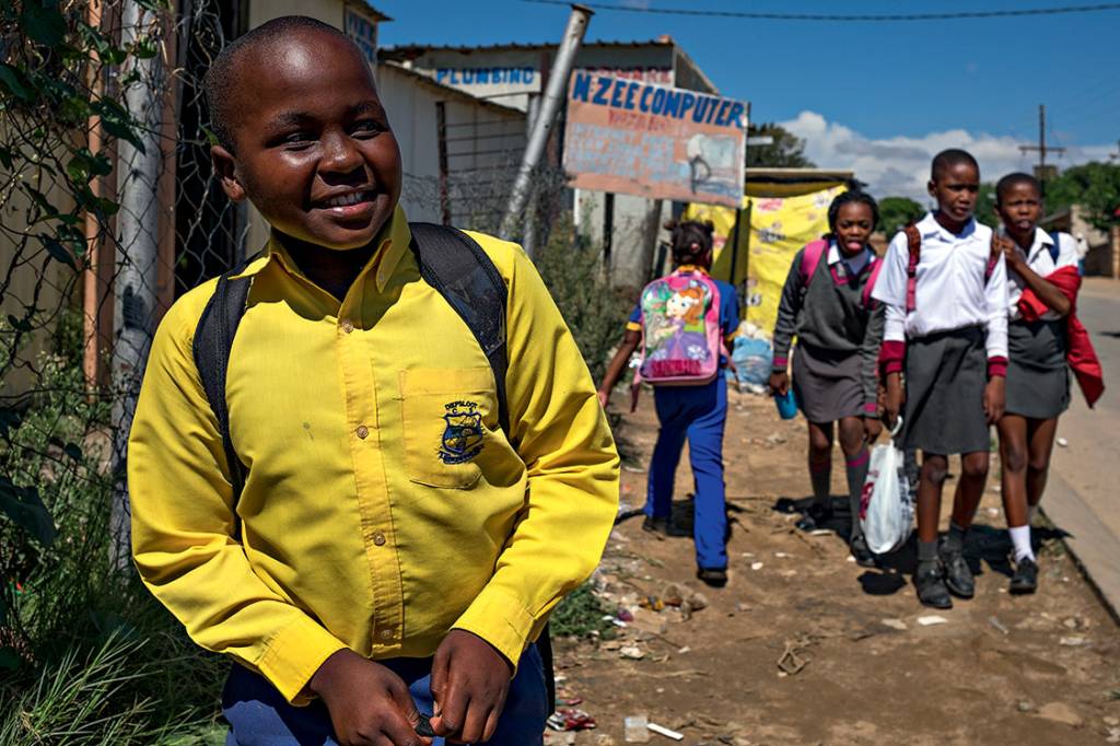 SORRISO E SIL&Ecirc;NCIO - Aos 14 anos, o estudante Tshepo Natamela (&agrave; esq.) conta que sua fam&iacute;lia sentiu na pele os efeitos do regime de segrega&ccedil;&atilde;o racial, mas prefere n&atilde;o levantar o assunto em casa. &ldquo;&Eacute; um machucado que ficou para eles. Para mim, n&atilde;o, a vida &eacute; boa, &eacute; leve, e eu adoro falar dela&rdquo;