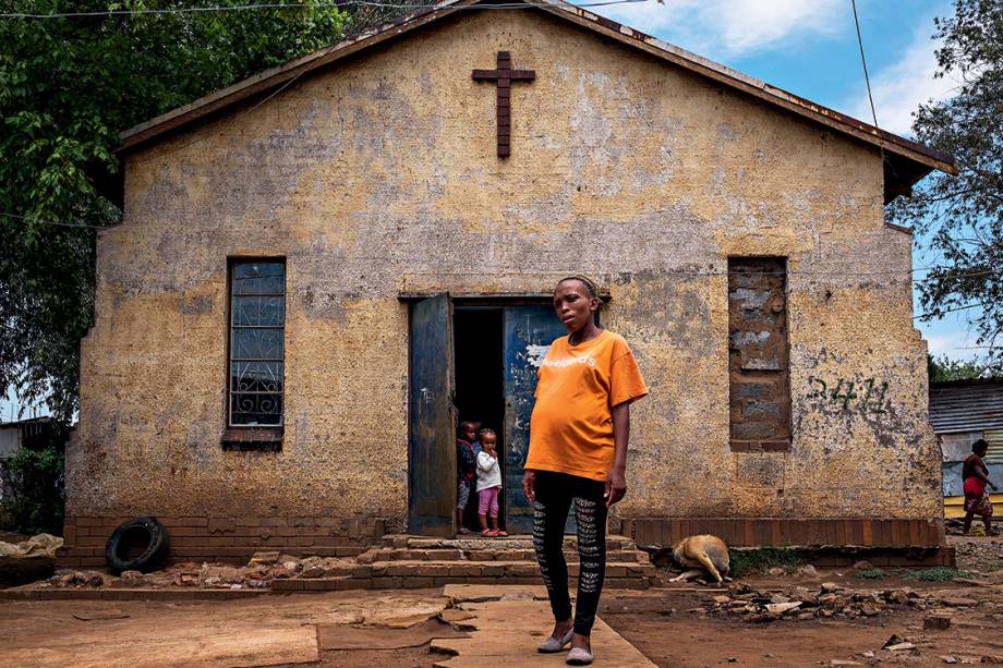 À espera do voo alto - Mãe de uma menina de 6 anos, a professora Fisokuhle Mdzebu, de 29 anos, exibe o barrigão de nove meses do segundo filho, em frente à igreja onde funciona a creche em que trabalha: “Meus pais não pisaram na escola, eu parei antes da faculdade, mas meus filhos certamente terão muito mais chances”, diz