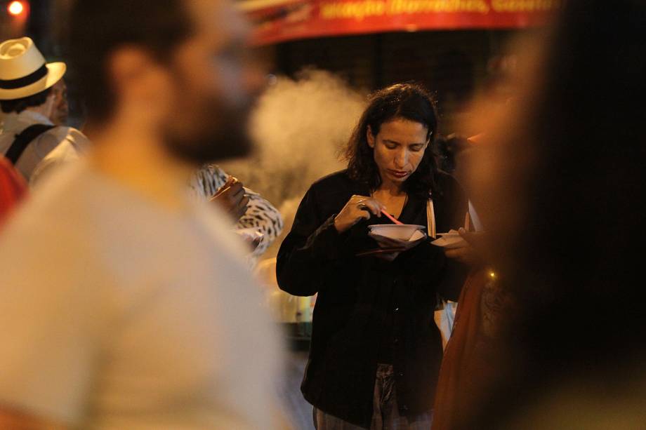 Mulher faz refeição durante a noite perto do local onde o ex-presidente está