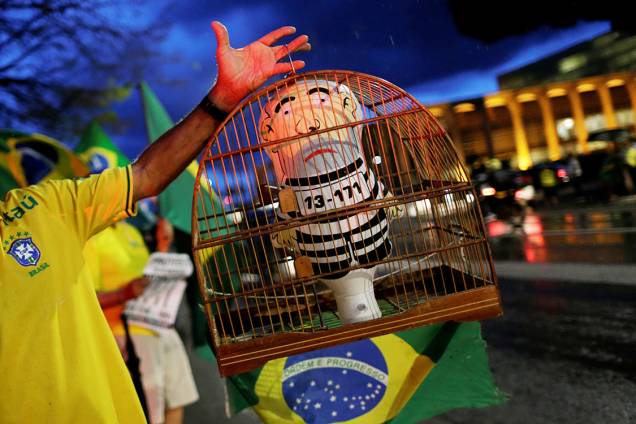 Manifestante mostra pixuleco em uma gaiola durante protesto contra o ex-presidente Lula, em Brasília Manifestante mostra pixuleco em uma gaiola durante protesto contra o ex-presidente Lula, em Brasília