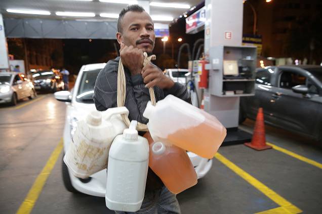 Homem carrega galões com gasolina em posto de combustível em Brasília - 26/05/2018 Homem carrega galões com gasolina em posto de combustível em Brasília - 26/05/2018