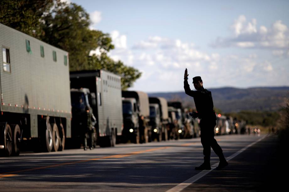 Oficial militar acena para caminhões do Exército na rodovia GO-010 em Goiás - 26/05/2018