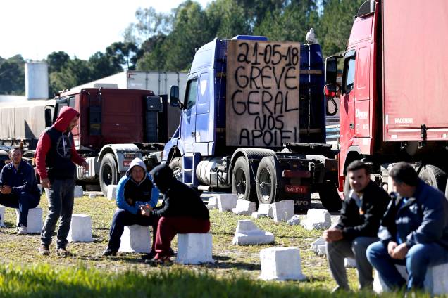 Caminhoneiros são vistos à beira da estrada após paralisarem a BR-116, em Curitiba, durante um protesto nacional contra o aumento do preço do combustível - 21/05/2018 Caminhoneiros são vistos à beira da estrada após paralisarem a BR-116, em Curitiba, durante um protesto nacional contra o aumento do preço do combustível - 21/05/2018