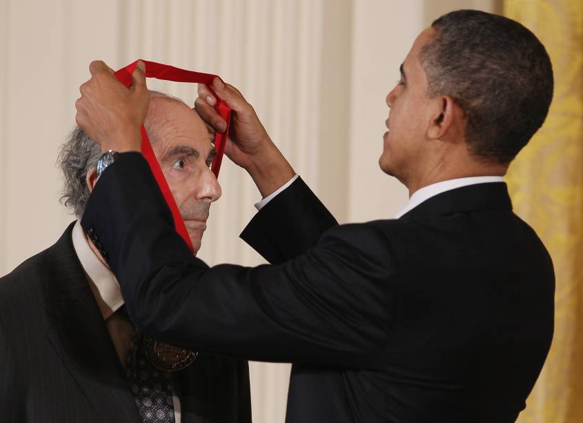 O ex-presidente dos Estados Unidos, Barack Obama, entrega a Medalha Nacional de Humanidades em 2011 para o romancista Philip Roth durante uma cerimônia na Sala Leste da Casa Branca