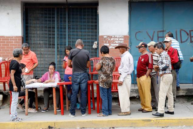 Cidadãos venezuelanos fazem check-in em um "ponto vermelho", área criada pelo partido do presidente Nicolás Maduro, para verificar se eles votaram durante a eleição presidencial em Barquisimeto - 20/05/2018 Cidadãos venezuelanos fazem check-in em um "ponto vermelho", área criada pelo partido do presidente Nicolás Maduro, para verificar se eles votaram durante a eleição presidencial em Barquisimeto - 20/05/2018