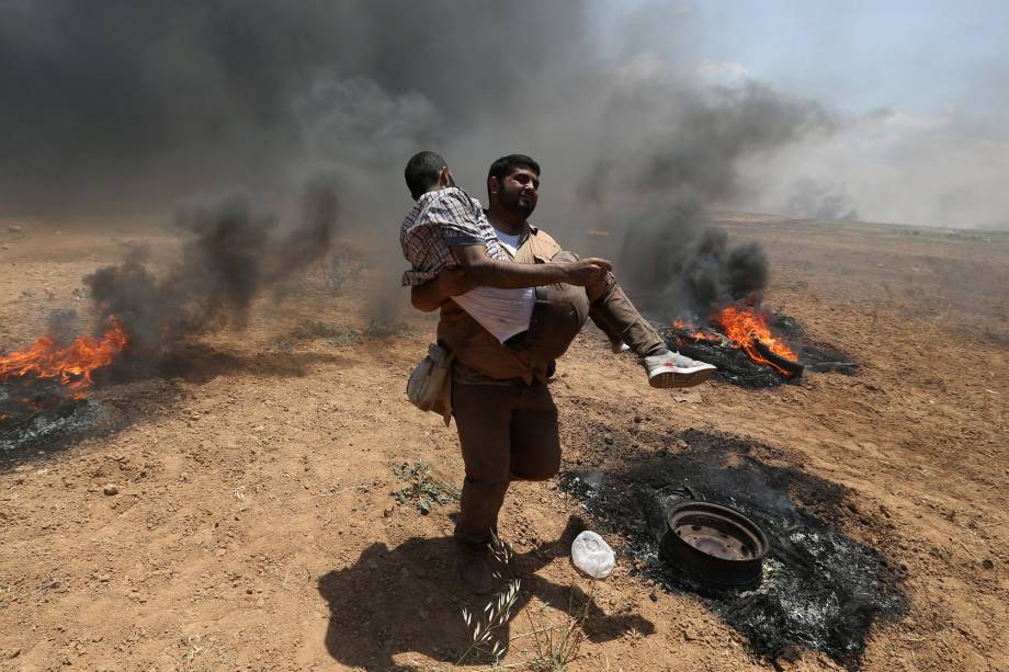 Manifestantes ferido é carregado durante protesto contra a mudança da embaixada americana para Jerusalém e antes do 70º aniversário de Nakba, na fronteira entre Israel e Gaza - 14/05/2018