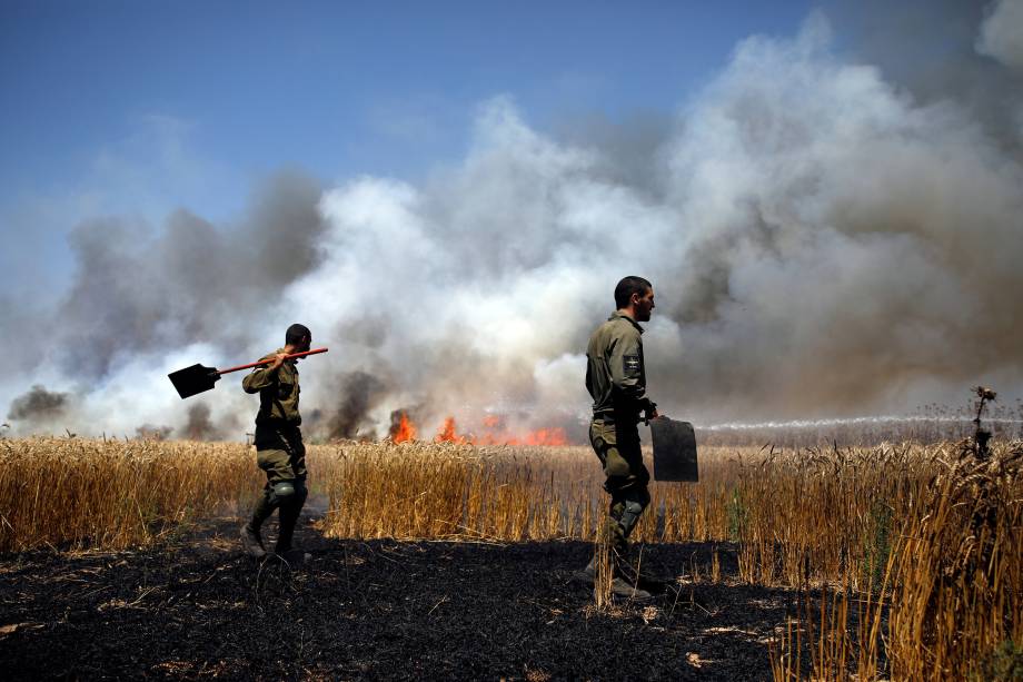 Soldados israelenses tentam extinguir um incêndio em um campo no lado israelense da fronteira entre Israel e Gaza, perto do kibutz Mefalsim - 14/05/2018 Soldados israelenses tentam extinguir um incêndio em um campo no lado israelense da fronteira entre Israel e Gaza, perto do kibutz Mefalsim - 14/05/2018