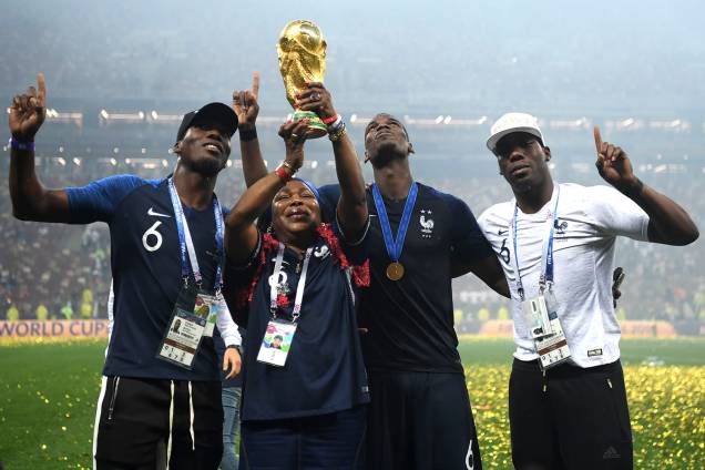 Yeo, a mãe do francês Paul Pogba, ergue a taça dos campeões do mundo enquanto comemora o título com seus filhos Mathias e Florentin - 15/07/2018 Yeo, a mãe do francês Paul Pogba, ergue a taça dos campeões do mundo enquanto comemora o título com seus filhos Mathias e Florentin - 15/07/2018