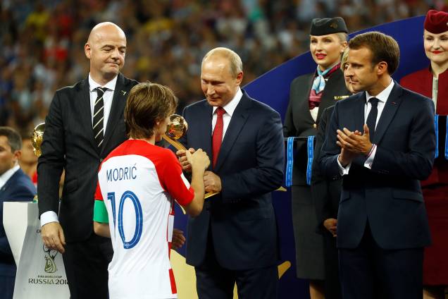 Luka Modric da Croácia recebe prêmio de Bola de Ouro do Presidente da Rússia Vladimir Putin enquanto o Presidente da FIFA Gianni Infantino e o Presidente Francês Emmanuel Macron observam - 15/07/2018 Luka Modric da Croácia recebe prêmio de Bola de Ouro do Presidente da Rússia Vladimir Putin enquanto o Presidente da FIFA Gianni Infantino e o Presidente Francês Emmanuel Macron observam - 15/07/2018