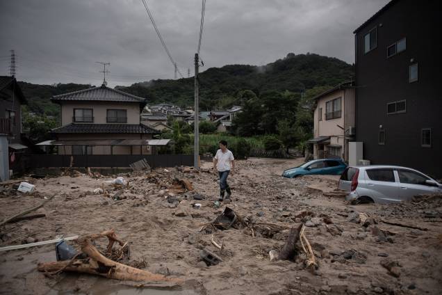 Um homem caminha por uma rua devastada durante as inundações em Saka, na província de Hiroshima, no Japão - 08/07/2018 Um homem caminha por uma rua devastada durante as inundações em Saka, na província de Hiroshima, no Japão - 08/07/2018