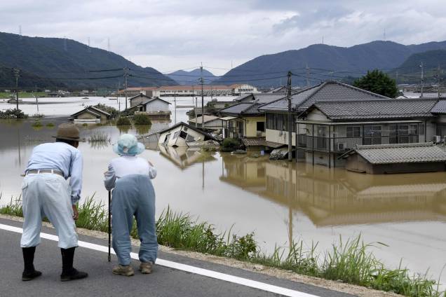 Casal de idosos olha para uma área inundada após a chuva pesada em Kurashiki, Prefeitura de Okayama, no Japão - 08/07/2018 Casal de idosos olha para uma área inundada após a chuva pesada em Kurashiki, Prefeitura de Okayama, no Japão - 08/07/2018