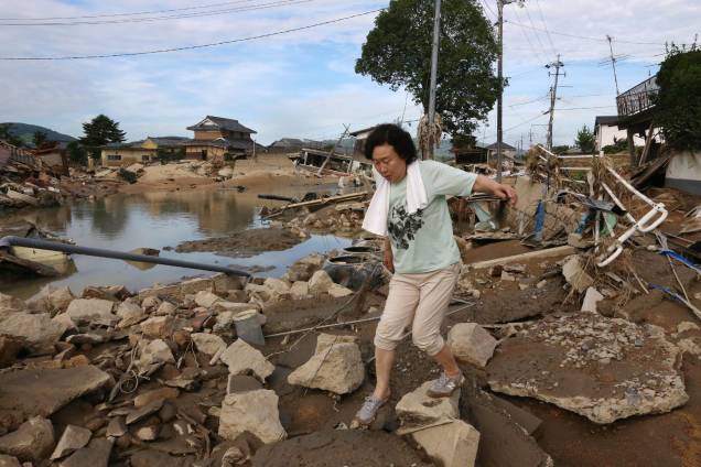 Moradora atravessa os escombros espalhados em uma área de enchente em Kurashiki, prefeitura de Okayama, no Japão - 09/07/2018 Moradora atravessa os escombros espalhados em uma área de enchente em Kurashiki, prefeitura de Okayama, no Japão - 09/07/2018