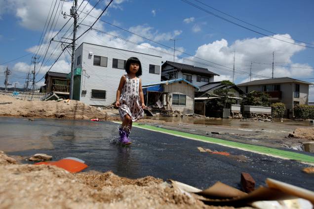 Criança caminha em uma área afetada pela enchente na cidade de Mabi em Kurashiki, Prefeitura de Okayama, Japão - 10/07/2018 Criança caminha em uma área afetada pela enchente na cidade de Mabi em Kurashiki, Prefeitura de Okayama, Japão - 10/07/2018