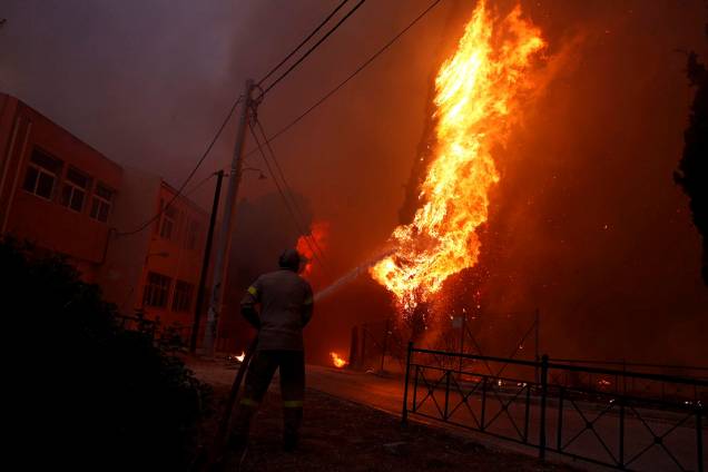 Bombeiro trabalha para conter as chamas de um incêndio florestal em Rafina, perto de Atenas, na Grécia - 23/07/2018 Bombeiro trabalha para conter as chamas de um incêndio florestal em Rafina, perto de Atenas, na Grécia - 23/07/2018